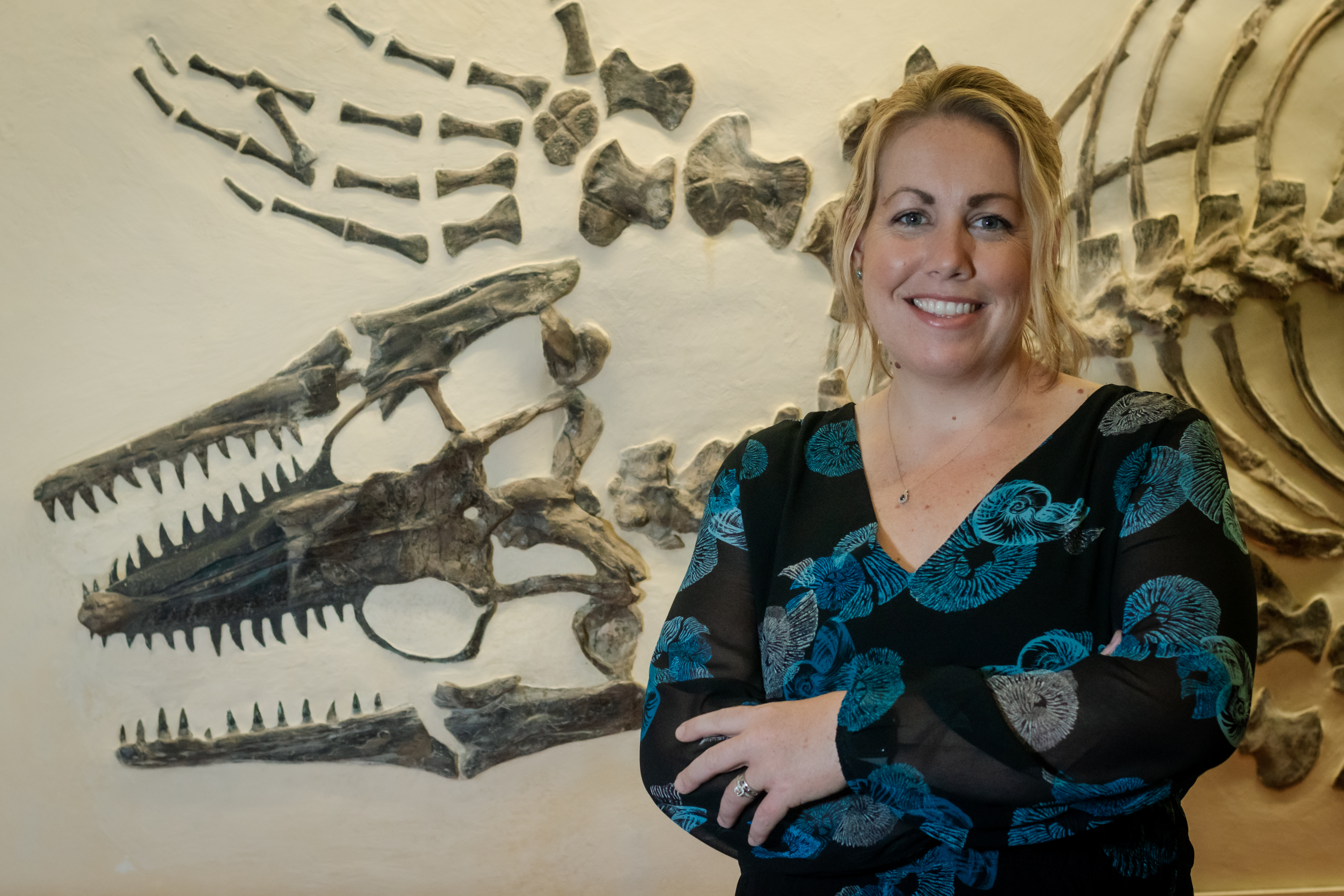 Laura standing in front of a mosasaur skeleton at the Sternberg Museum.